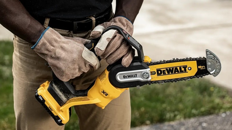 person holding DeWalt mini chainsaw