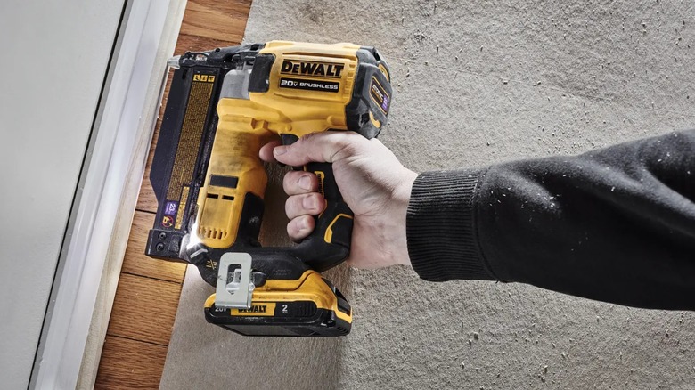 securing baseboard with DeWalt pin nailer