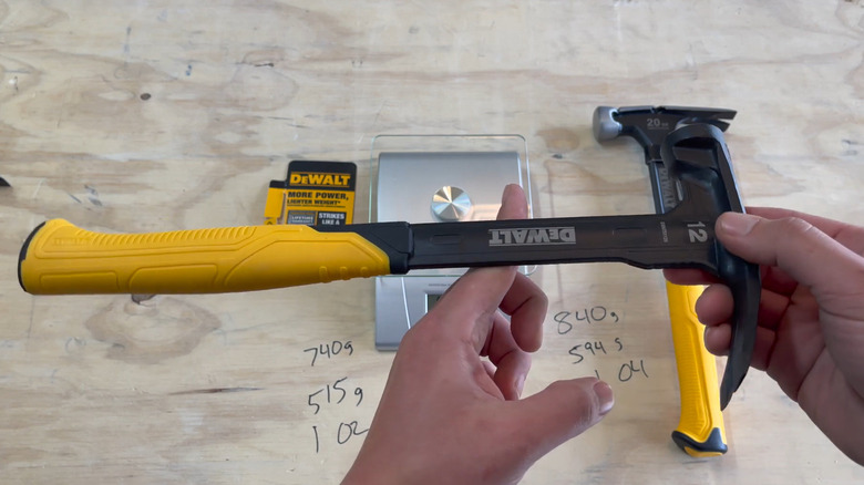 A worker horizontally balancing a DeWalt 12 oz. hammer by one finger