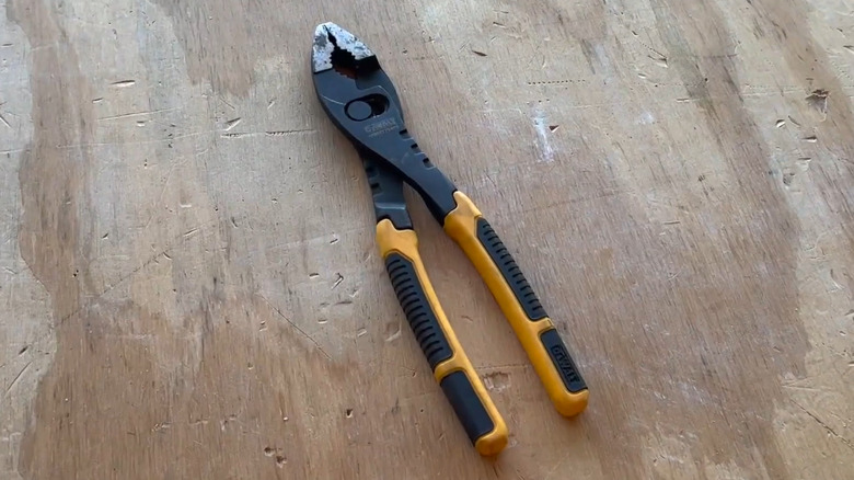 A pair of DeWalt slip joint pliers on a work bench