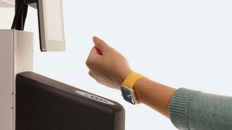 A person scanning their documents with Apple Watch at an airport checkpoint