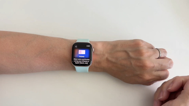 A person using a transit card on their Apple Watch