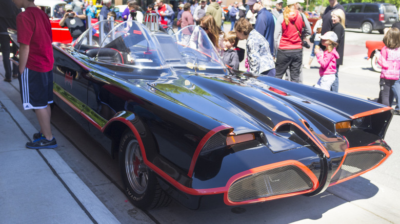 The Batmobile from "Batman" on display with onlookers admiring the car