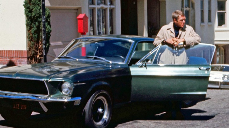 Frank Bullitt standing beside his 1968 Ford Mustang GT390 Fastback with the door open in "Bullitt"