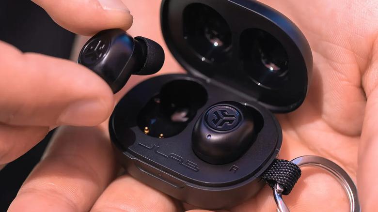 Man holding earbuds in their palm
