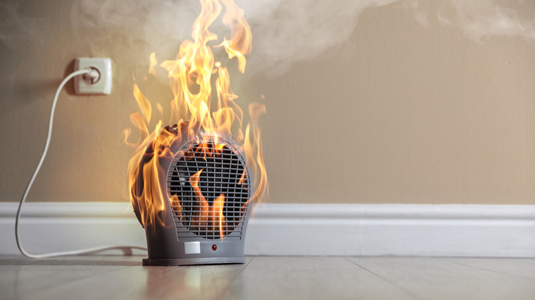 A space heater plugged into the wall that's on fire