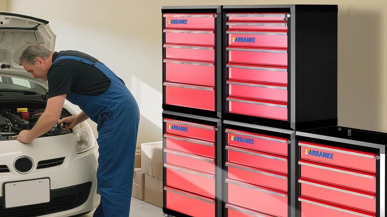 A person working on a car next to a locking tool drawer.