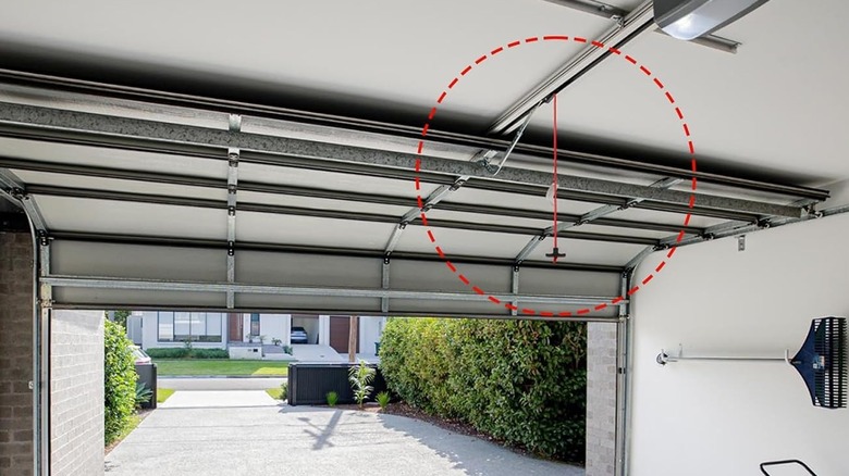 A photo of an emergency release cord in a garage with a red circle around it.