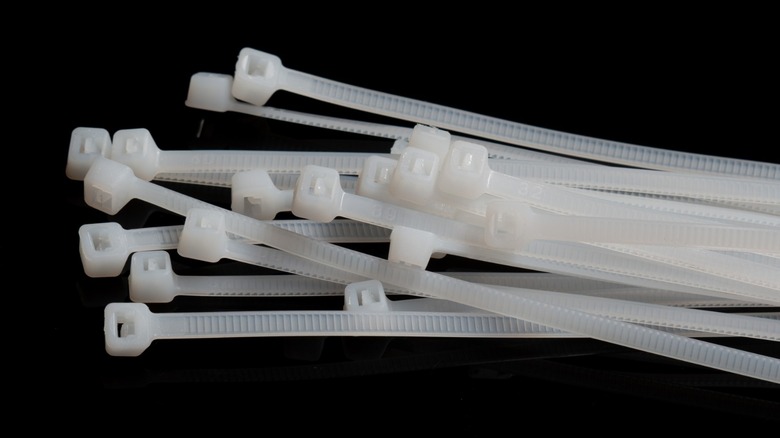 a collection of white zip ties on a black background