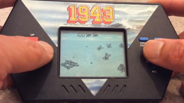 A person playing the Acclaim 1943 handheld LCD game