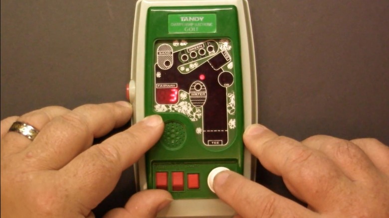 A person playing the Tandy Championship Electronic Golf handheld game