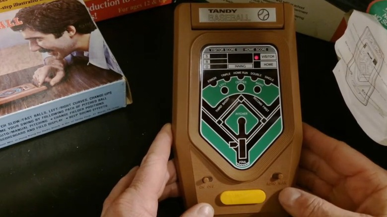 A person playing the Tandy Electronic 2-Player Baseball handheld game
