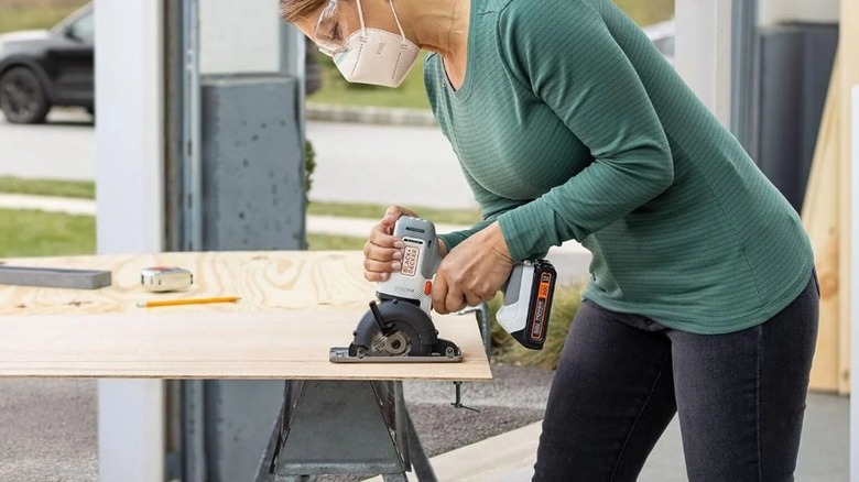 woman using Black & Decker Matrix Trim Saw Attachment on drill