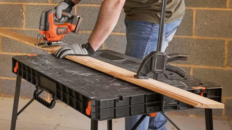 Man cutting wood on Black & Decker Foldable Workbench