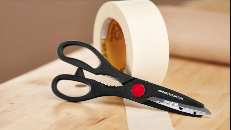 Stock image of a pair of black scissors with red pivot point
