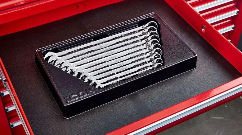 An Anti-Slip Grip Professional Metric Ratcheting Combination Wrench Set in a red toolbox with a black surface that has a leather texture