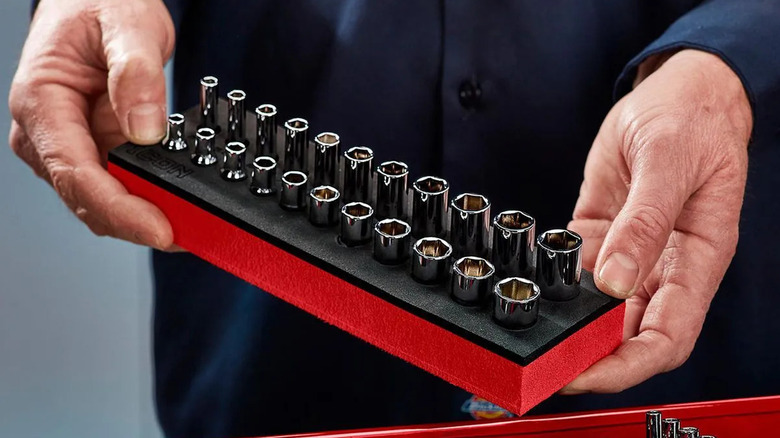 A person holding the Drive SAE and Metric Modular General Service Socket Set