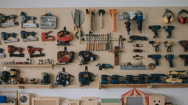 A workshop with a variety of tools lined up on the wall