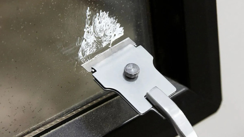 A scraper in use on a metallic surface
