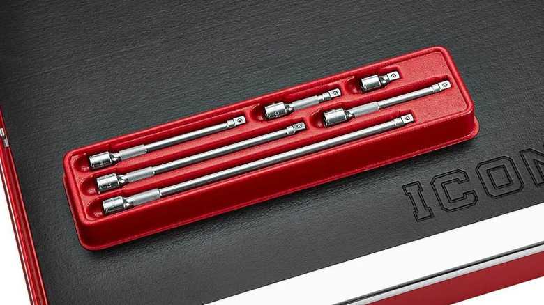 A red Professional Socket Extension Set on a black surface with a leather texture, with the letters "ICON" spelled out on the bottom-right
