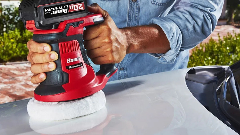 Person using a Bauer polisher to polish a car hood
