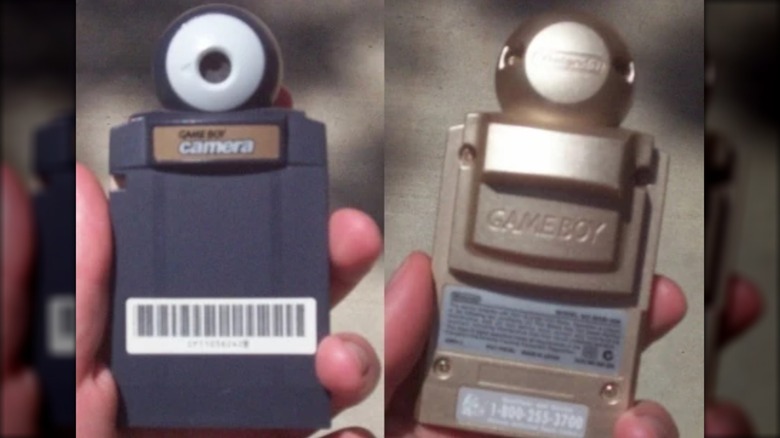 A hand holding the Game Boy Camera (Gold Edition)