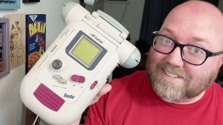 A smiling man holding the Saitek Booster Boy
