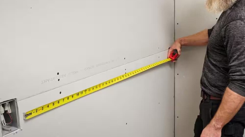 A whole tape measure against a wall.