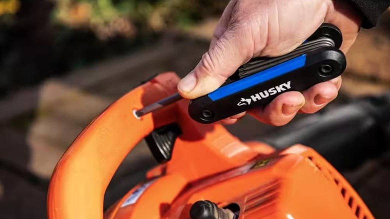 A folding hex key set being used on a tool.