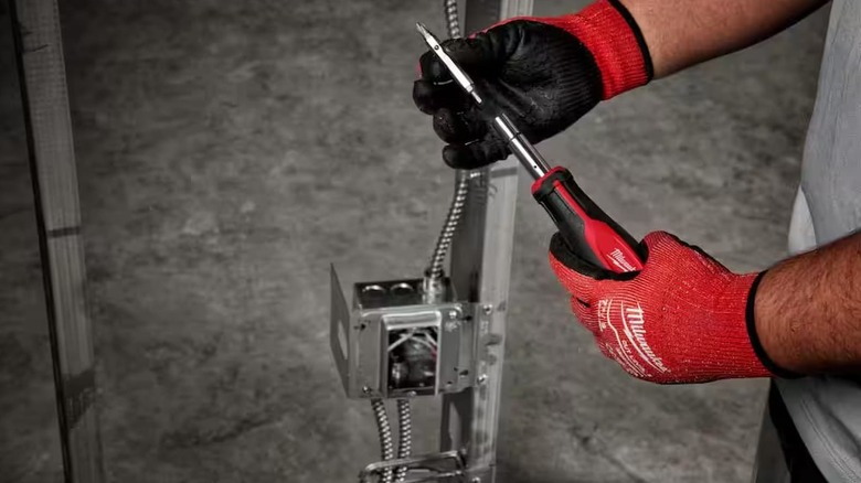 A wrench getting put together by someone with gloves.