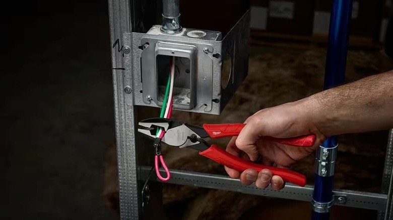 A person cutting some wire with lineman's pliers.