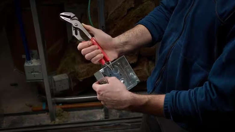 A person using a tool on a box.