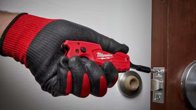 Milwaukee utility knife being used as a screwdriver