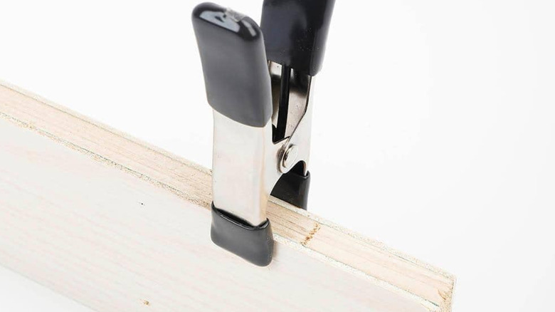 Closeup of an Anvil 1-Inch Spring Clamp used to hold wood.