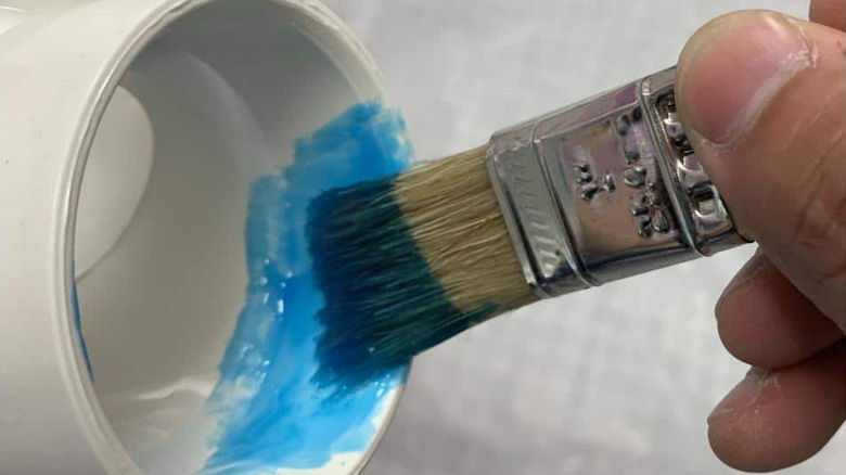 Home Depot's 1-Inch Flat Chip Brush used to paint a small item.