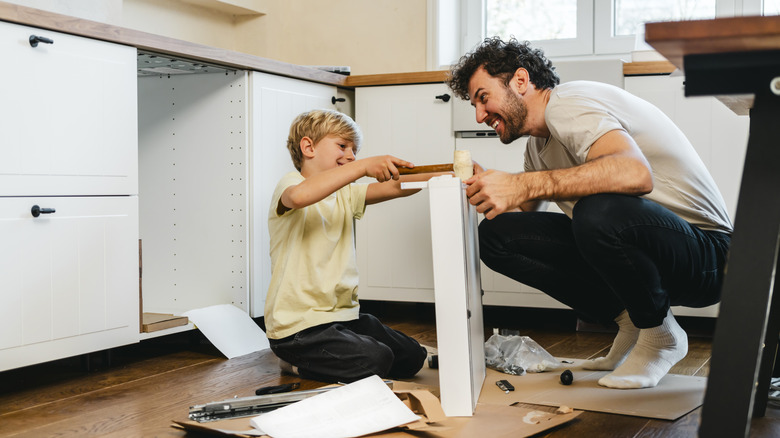 father and son assembling drawers