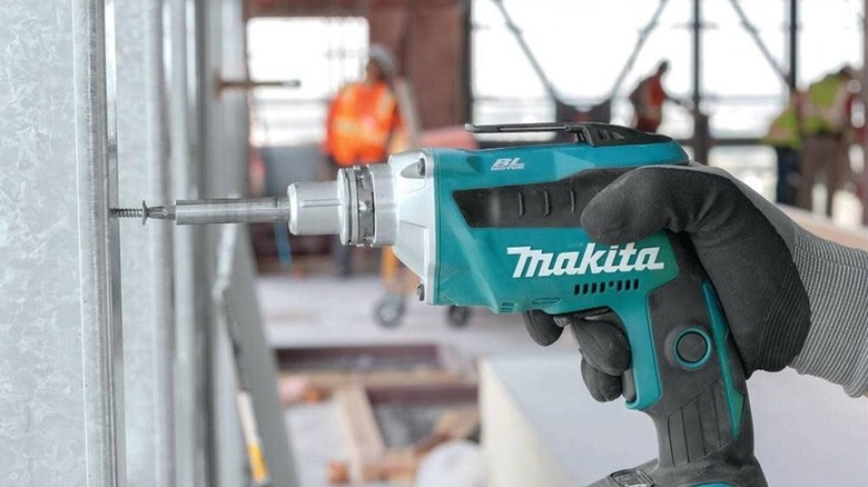 Makita XSF03Z drywall screwdriver driving a screw into a beam