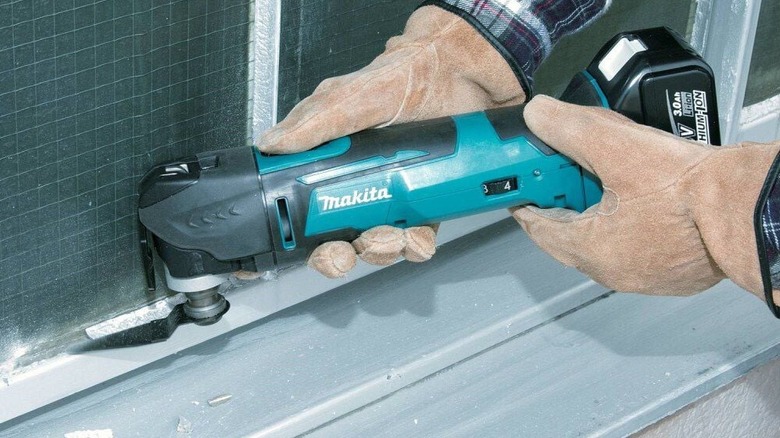 DIYer using Makita XMT03Z oscillating multi-tool