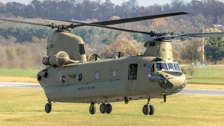 The Boeing CH-47F Chinook taking off from a field