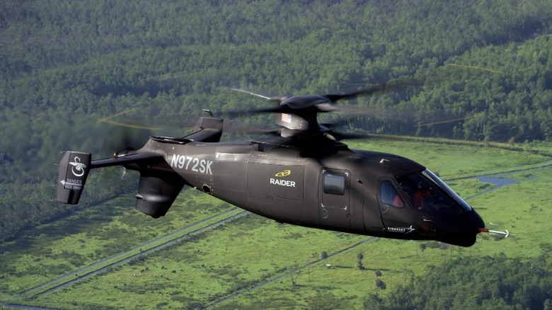 The Sikorsky S-97 Raider flying over a forest area