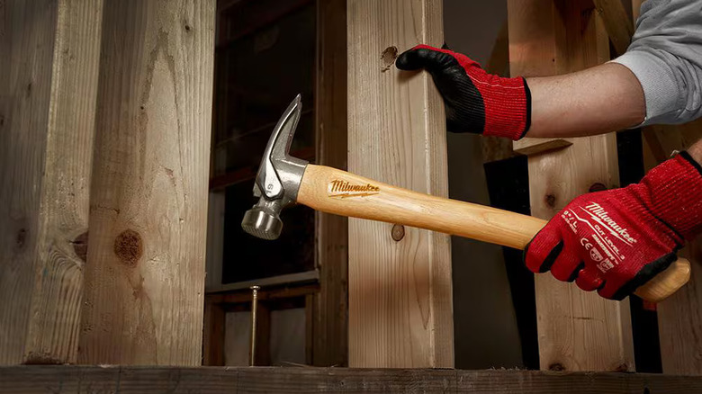 Professional using a Milwaukee 19-ounce framing hammer