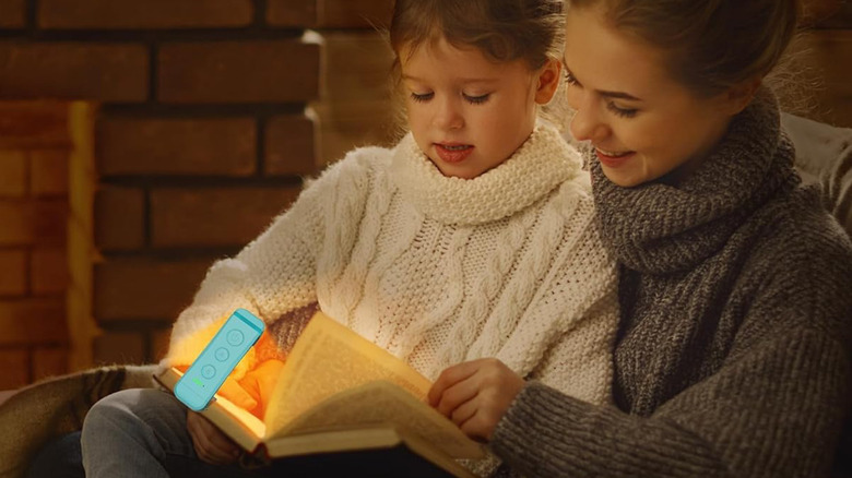 A mother reading to her daughter with the Gloucent Clip-On Book Light lighting up the pages.