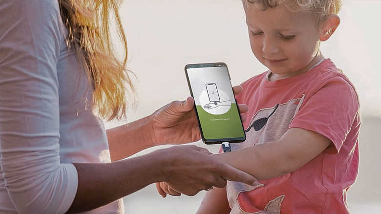 A mother applying heat to a child's bite with th Heat It Insect Bite Healer.