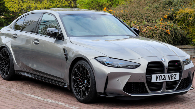 A silver BMW M3 in a parking space
