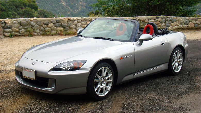 A silver Honda S2000 parked on a gravel road