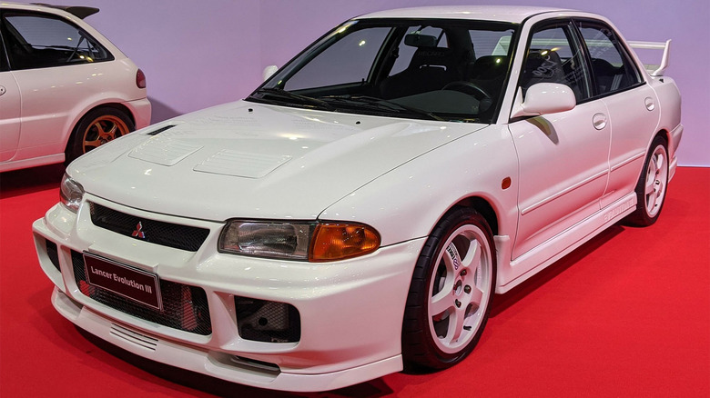 A white Lancer Evolution on a red carpet