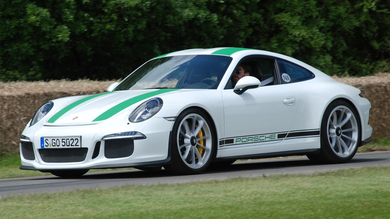 A white and green Porsche 911 on a race track