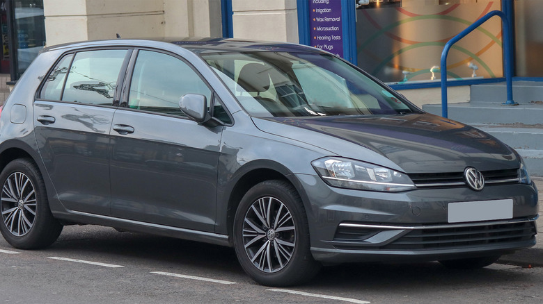 A dark gray Golf R packed on a city street