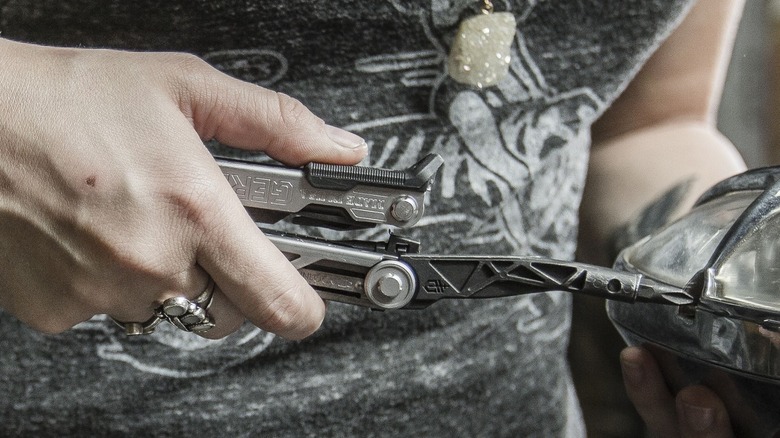 Man using Gerber multi-tool as phillips screwdriver