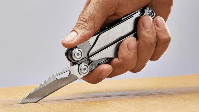 Man using Harbor Freight Gordon multi-tool to open box
